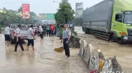 Aparat gabungan berusaha meminimalisir genangan air yang berada di jalan utama kota Bekasi (Foto: Antara)